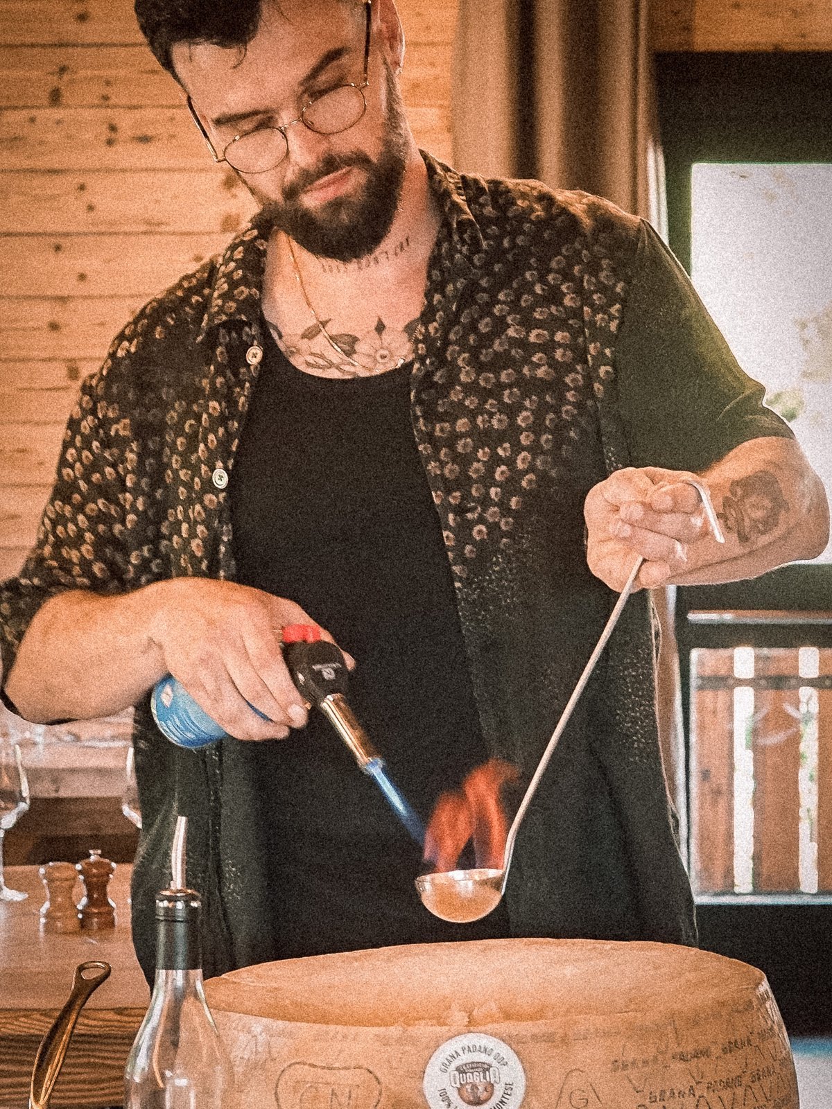 Le chef flambe la meule de parmesan devant les clients