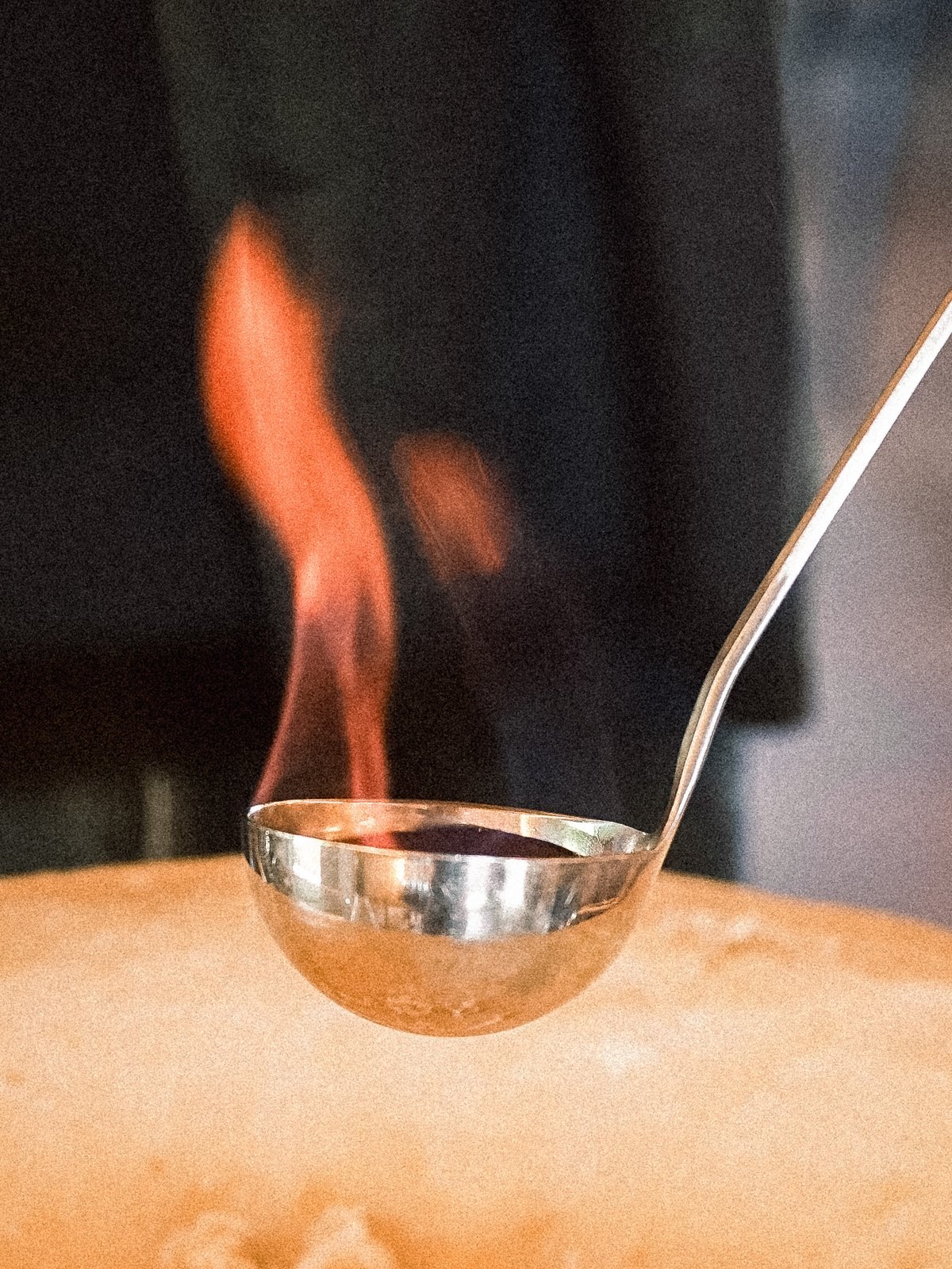 Cognac flambé versé dans la meule de grana padano